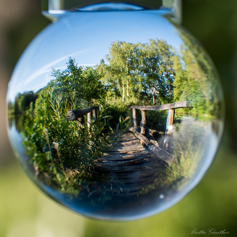 Die Brücke im See durch die Glaskugel